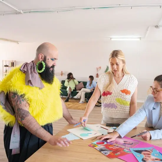 Hombre y 2 mujeres reunidos discutiendo la estrategia de branding